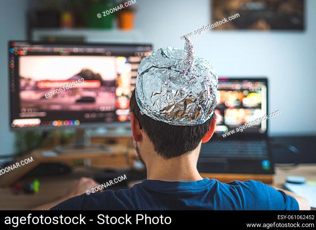 Young man is wearing aluminum cap, conspiracy theory concept