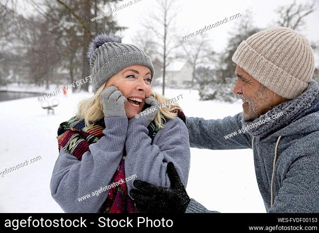 Senior man looking at woman at park during winter