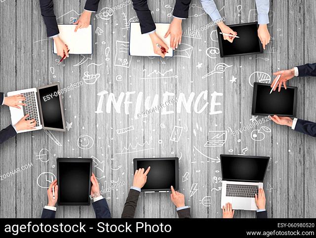 Group of business people working in office with INFLUENCE inscription, coworking concept