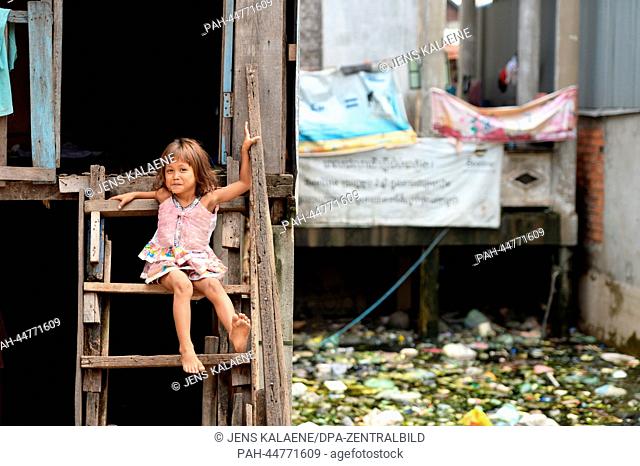 The girl Srey Mao (5) sits in front of her house in the Chhba Anmpov Slum on the grounds of a Chinese graveyard in Phnom Penh, Cambodia, 10 December 2013