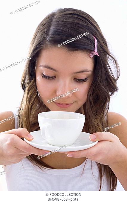 Girl smelling a scented cup of tea