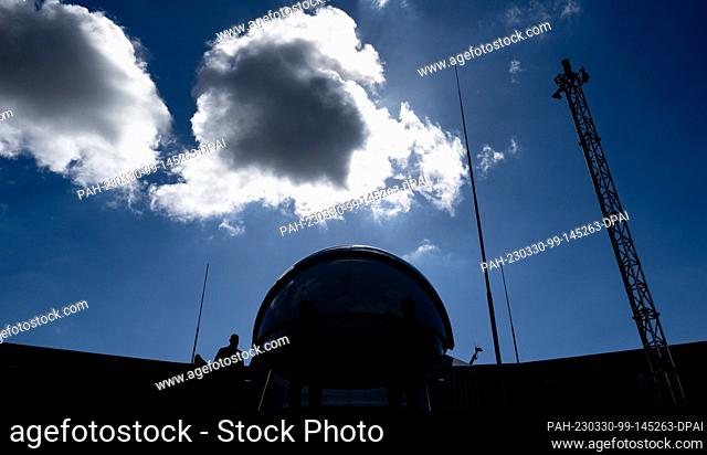PRODUCTION - 27 March 2023, Saxony-Anhalt, Halle (Saale): The dome of the observatory on the roof of the planetarium can be seen against the light