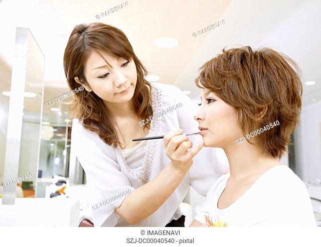 A young woman getting her makeup done