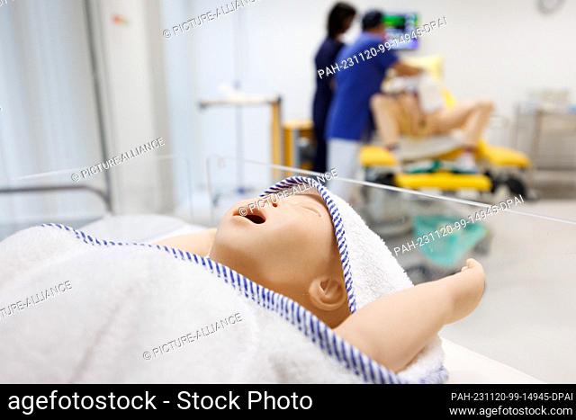 20 November 2023, Lower Saxony, Osnabrück: The dummy of an infant lies in a bed in the simulation laboratory of the Midwifery Science course at Osnabrück...