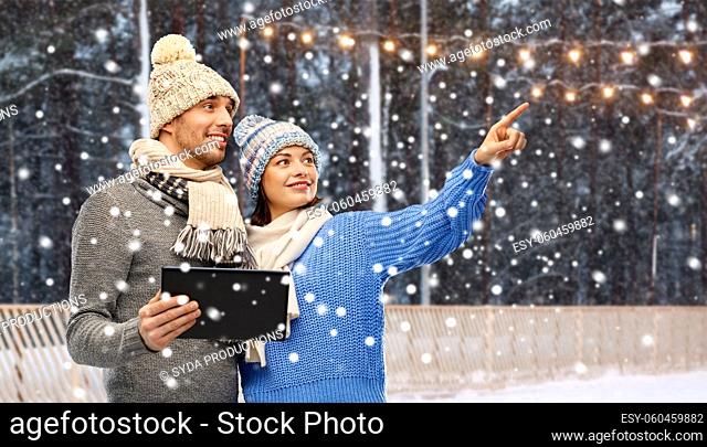 couple in winter clothes with tablet computer