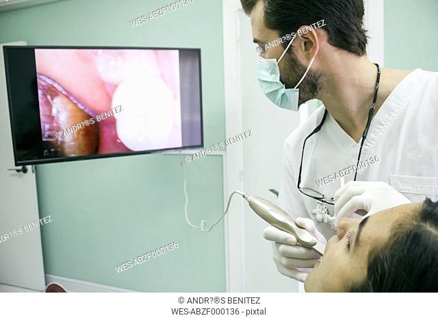 Dentist examining the mouth of a patient with an intraoral camera