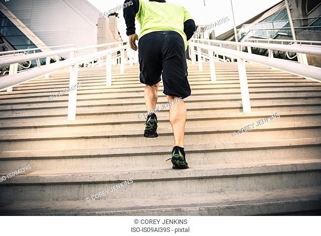 Cropped shot of mature male runner training on steps