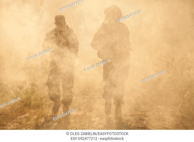 United States Marines in action. Military equipment, army helmet, warpaint, smoked dirty face, tactical gloves. Military action, desert battlefield