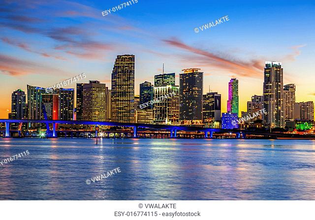 CIty of Miami Florida, summer sunset panorama with colorful illuminated business and residential buildings and bridge on Biscayne Bay