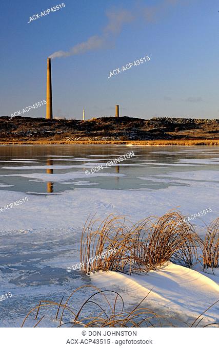 Vale Superstack reflected in fresh ice on Kelly Lake, Lively, Greater Sudbury, Ontario, Canada