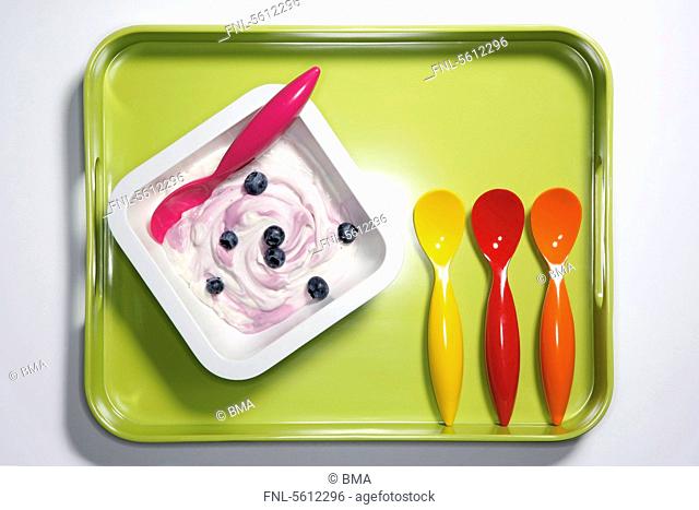Blueberry curd with plastic spoons on tray