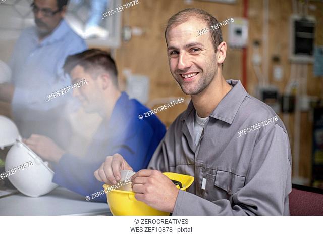 Smiling young man attending an electrician workshop