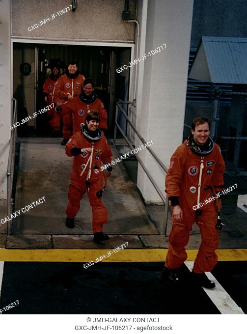 Members of the flight crew walk out of the Operations and Checkout Building (OCB) at Kennedy Space Center (KSC) to enter the Astrovan which will take them to...