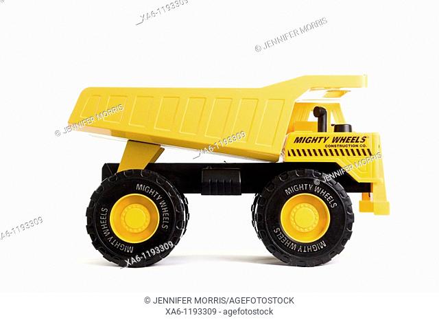 A bright yellow toy dumper truck in profile against a white background