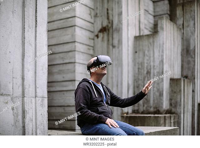 A middle aged man wearing a virtual reality headset