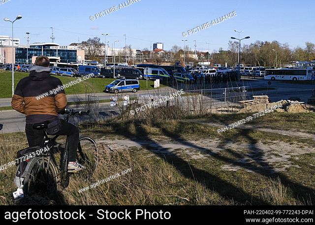 02 April 2022, Mecklenburg-Western Pomerania, Rostock: A man looks from a distance at the main train station, in front of which police forces have gathered as...