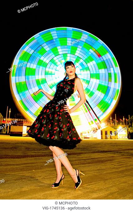 A beautiful pin up model posing infront of a ferriswheel at night. - 16/05/2007