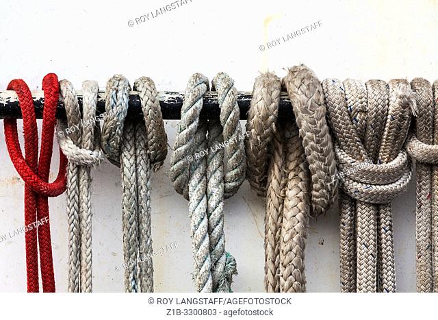 Ropes secured to a handrail on the cabin of a commercial fishing vessel