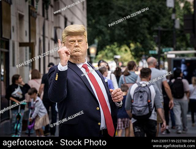 16 September 2023, USA, New York: A man wearing a Donald Trump mask directs traffic in front of Trump Tower on 5th Avenue in Manhattan
