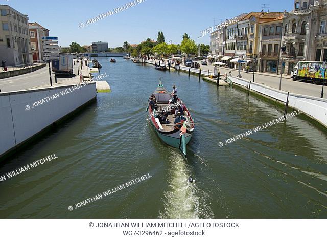 AVEIRO, PORTUGAL - June 28, 2016: Tourists enjoy a guided boat tour in a traditional Moliceiro boat in Aveiro, Portugal