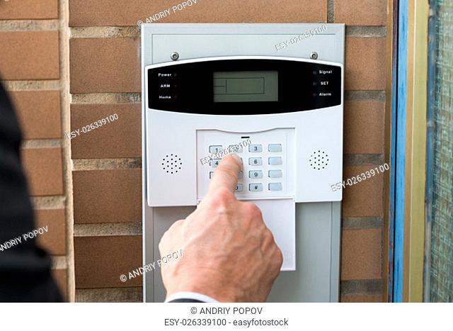 Close-up Of Businessperson Hand Entering Code In Security System