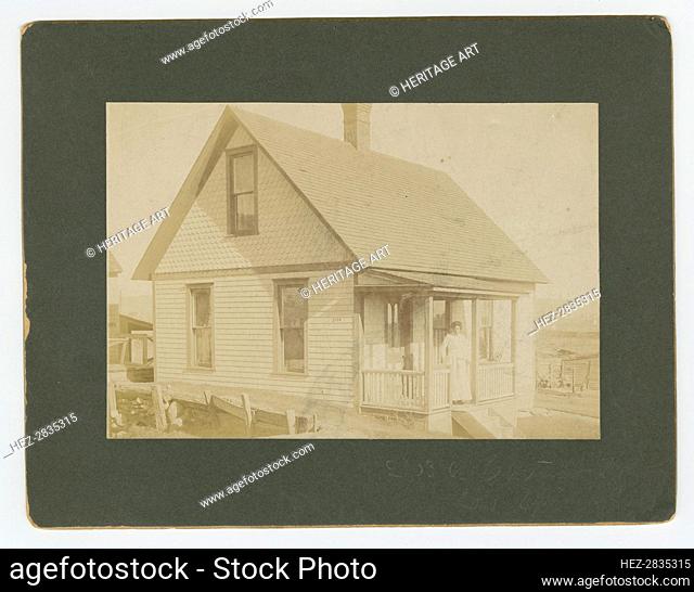 Photograph of a woman standing on the porch of a house, early 20th century. Creator: Unknown