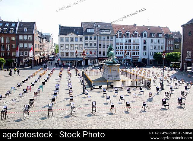 24 April 2020, North Rhine-Westphalia, Duesseldorf: Empty chairs stand in front of the town hall and surround the Jan Wellem monument