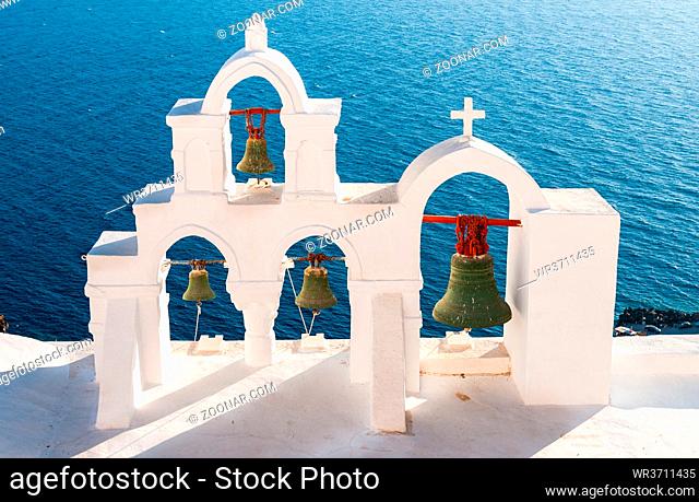 Traditional white Blue Christian church dome belfry and metal bells. Santorini island in Greece. Greek islands summer holidays