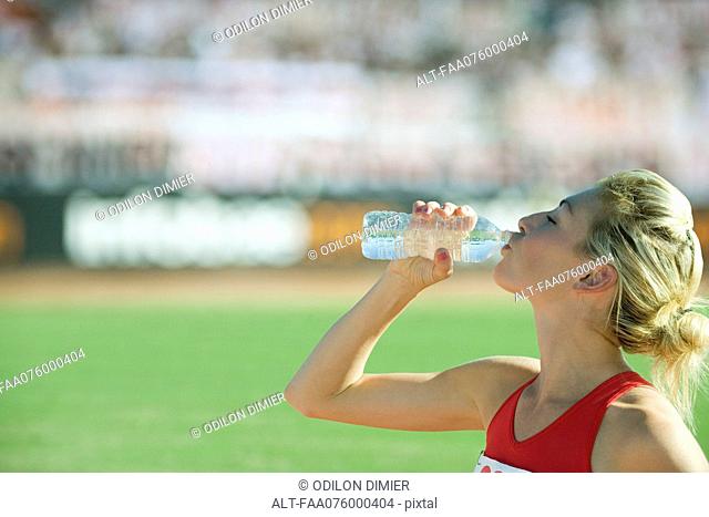 Female athlete drinking bottled water