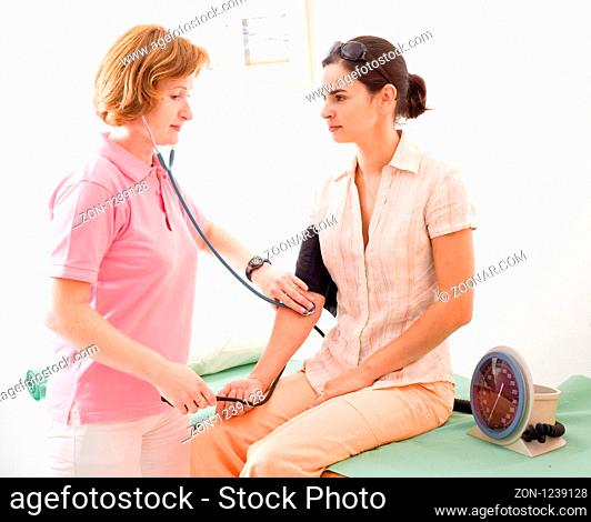 Nurse measuring the patient's blood-pressure
