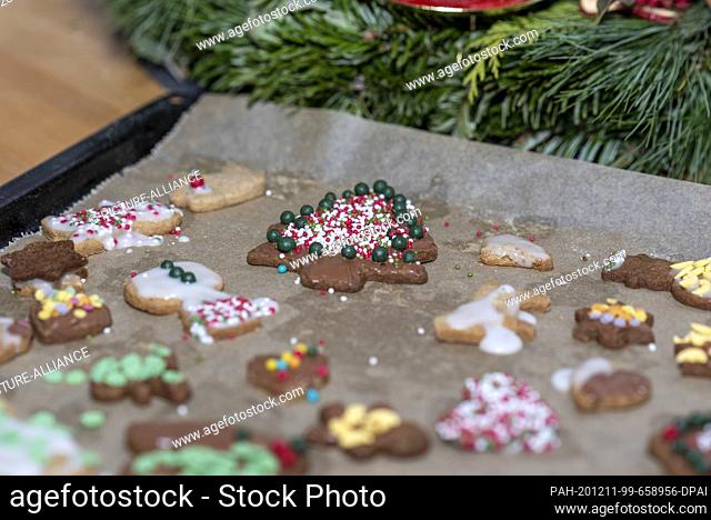 10 December 2020, Saxony-Anhalt, Magdeburg: A Christmas tree decorated with colourful sugar balls and chocolate lies on a tray next to other Christmas cookies