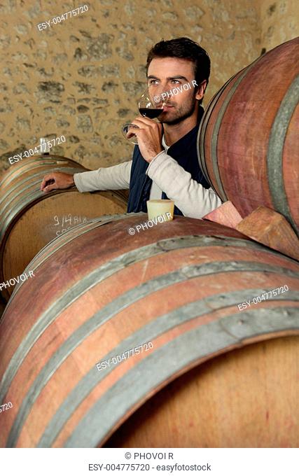 Man tasting wine in a cellar