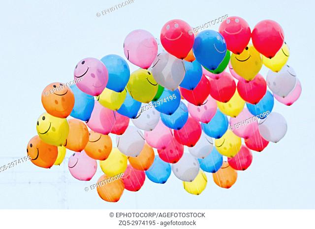 Bunch of vibrant color balloons with smiley face in the sky, Pune, Maharashtra