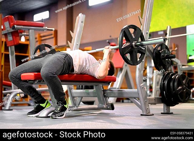 Young Man Doing Bench Press Workout In Gym. High quality photo