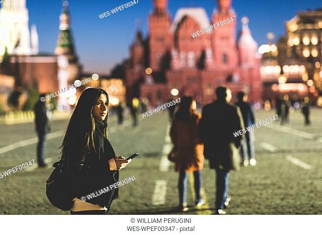 Russia, Moscow, young woman visiting Red Square at night