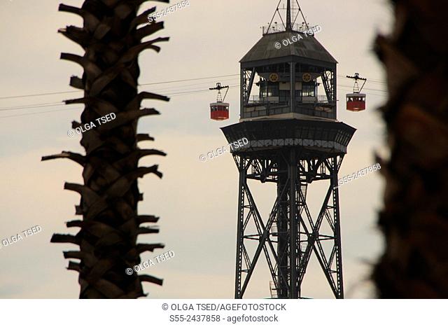 Barcelona cable car tower between palm trees. Maremagnum area, Port Vell, Barcelona, Catalonia, Spain