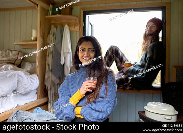 Portrait happy young couple relaxing in tiny cabin rental