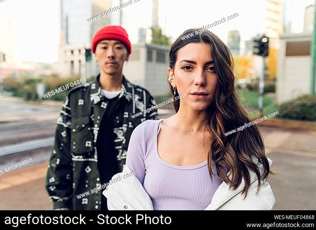 Woman with long hair standing with man at footpath