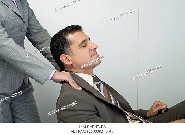 Mature businessman having shoulders massaged