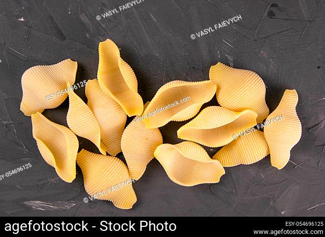 Conchiglie pasta shell composition on black background with clipping path. Concept of dough products and pastry