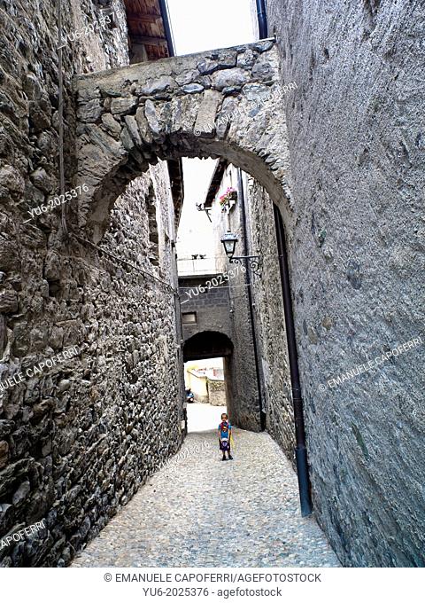 Child in an ancient street of the medieval town of Bormio, Sondrio, Italy