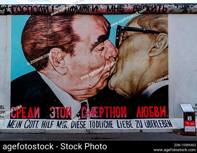 Berlin, Germany - 25 August 2020: view of a mural on the Berlin Wall at the famous East Side Gallery with information plaque