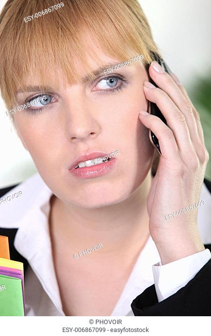 Closeup of an attractive redhead using a cellphone