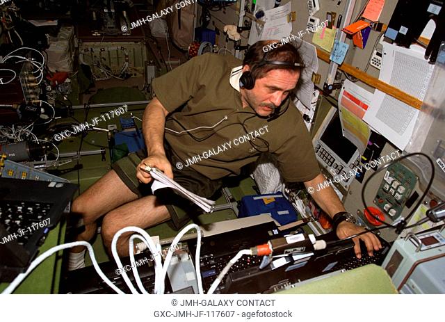 Cosmonaut Pavel V. Vinogradov, Expedition 13 commander representing Russia's Federal Space Agency, uses a communication system while working with equipment in...