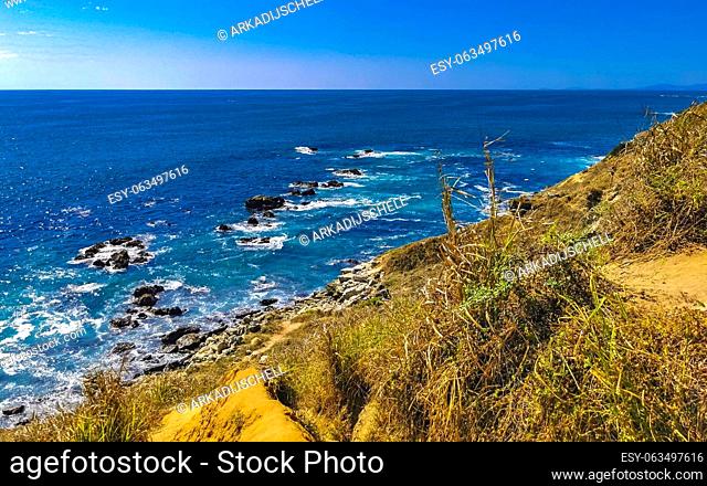 Beautiful rocks cliffs stones and boulders and huge big surfer waves and natural panorama view on the beach in Bacocho Puerto Escondido Oaxaca Mexico