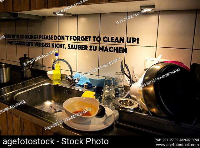 25 November 2020, Berlin: Dishes on a sink. On the wall it says ""Pre-cooked? Don't forget to clean!"". The hostel in Berlin-Moabit functions as a dormitory for...
