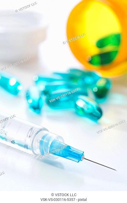 Syringe and blue capsules