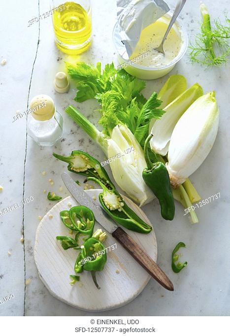 An arrangement of ingredients with chicory, fennel, peperoni, yoghurt and olive oil