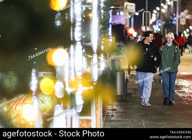 RUSSIA, LUGANSK - DECEMBER 20, 2023: A couple stroll past Christmas decorations glowing on Sovetskaya Street. Alexander Reka/TASS
