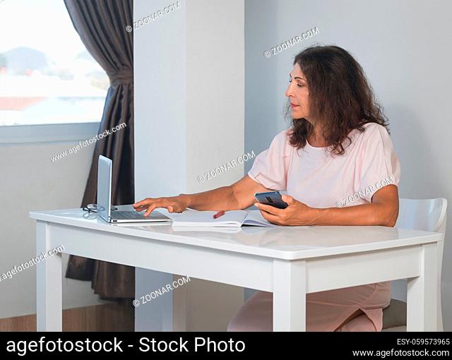 Indoor portrait of a beautiful smiling senior woman working at home